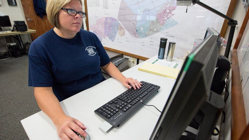 Stephanie Nevin, Wright-Patterson Air Force Base Fire Department emergency vehicle dispatcher, works on GeoBase, a detailed online map that uses a graphical user interface and overlays to allow first responders to see detailed information all around the base Aug. 27. (Common access card digitally covered for security reasons) (U.S. Air Force photo/John Harrington)