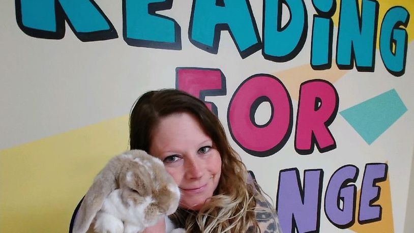 Amie Jones of Troy volunteers with pet therapy using a rabbit.