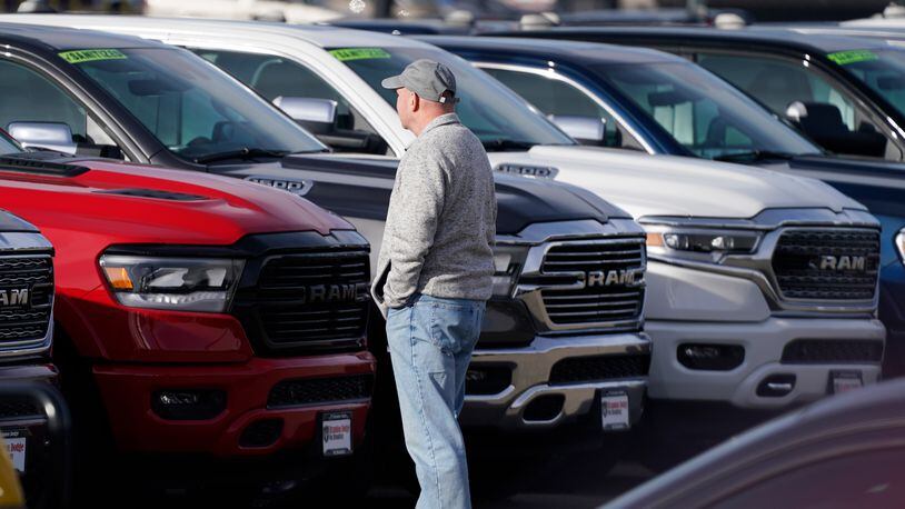 A prospective buyer surveys a long row of unsold 2020 pickup trucks at a Ram dealership, Sunday, Dec. 27, 2020, in Littleton, Colo. (AP Photo/David Zalubowski)