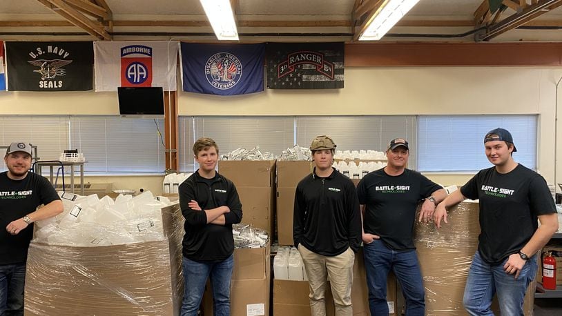 Battle Sight Technologies workers with boxes of newly produced hand sanitizer ready for the front lines. CONTRIBUTED