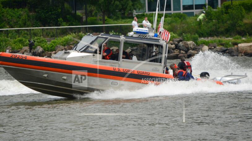 In this Sunday, May 28, 2017 photo, U.S. Coast Guard rescue a U.S. Navy Seal who fell into the Hudson River after his parachute failed to open during a Fleet Week demonstration over the river in Jersey City, N.J. The Navy said the parachutist was pronounced dead at Jersey City Medical Center. (Joe Shine/The Jersey Journal via AP)