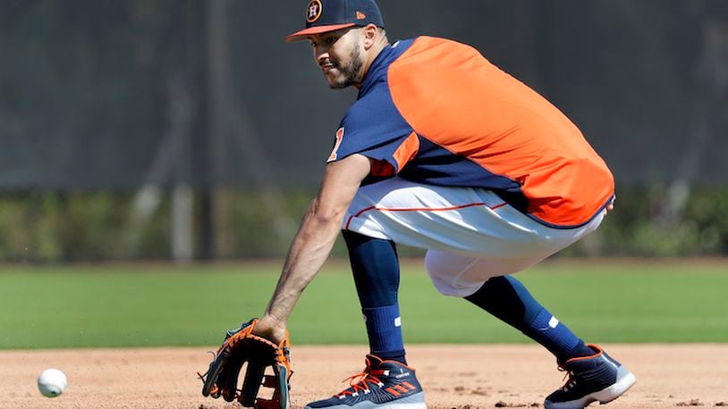 Houston Astros infielder Carlos Correa handles a grounder during spring training baseball practice Monday, Feb. 19, 2018, in West Palm Beach, Fla. (AP Photo/Jeff Roberson)