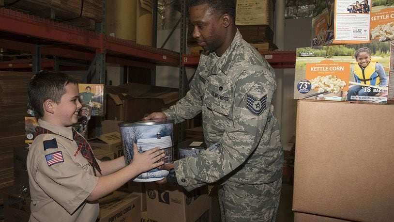 U.S. Air Force Tech Sgt. James Stembridge, 88th Logistics Readiness Squadron transportation management, receives a popcorn canister from Spencer Cabral as part of the Miami Valley Council Boy Scouts of America annual popcorn donation to Airmen Nov. 30. (U.S. Air Force photo/Michelle Gigante)