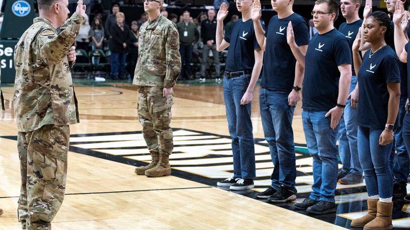Col. Michael Phillips, 88th Air Base Wing vice commander, administers the oath of enlistment to 19 members of the delayed enlistment program during the Wright State University Men’s Basketball Military Appreciation Night at the Nutter Center Jan. 18. Members of the military also presented the game ball, sung the national anthem and presented the colors during the pregame ceremonies. (U.S. Air Force photo/Wesley Farnsworth)