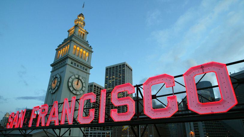 A neon sign glows atop the historic Ferry Building in San Francisco, Calif., on April 24, 2003.