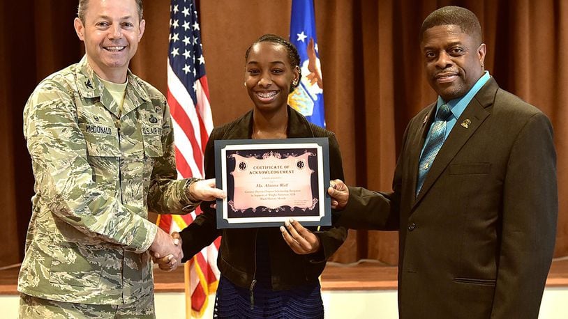 Col. Bradley McDonald (left), 88th Air Base Wing commander, and Terrance Williams (right), president of the local Greater Daytonl Blacks in Government chapter, present the annual Black History Month Scholarship to Alanna Wall, a senior at Stivers High School for the Arts, in a ceremony at Wright-Patterson Air Force Base, Feb. 21. Black History Month is an annual celebration of achievements by African Americans and a time for recognizing the central role of blacks in U.S. history. (U.S. Air Force photo/Al Bright)