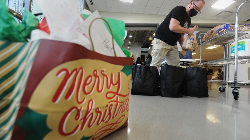A Southbrook Christian Church volunteer places food items into bags, Sunday, Dec. 20, 2020. The food will be distributed to people in need. MARSHALL GORBY\STAFF