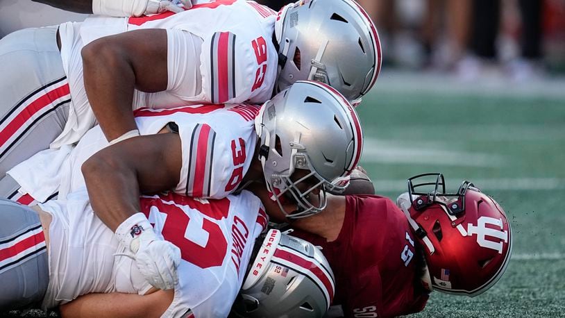 Indiana quarterback Brendan Sorsby (15) is sacked by Ohio State's Hero Kanu (93), Cody Simon (30) and Caden Curry (92) during the second half of an NCAA college football game, Saturday, Sept. 2, 2023, in Bloomington, Ind. (AP Photo/Darron Cummings)