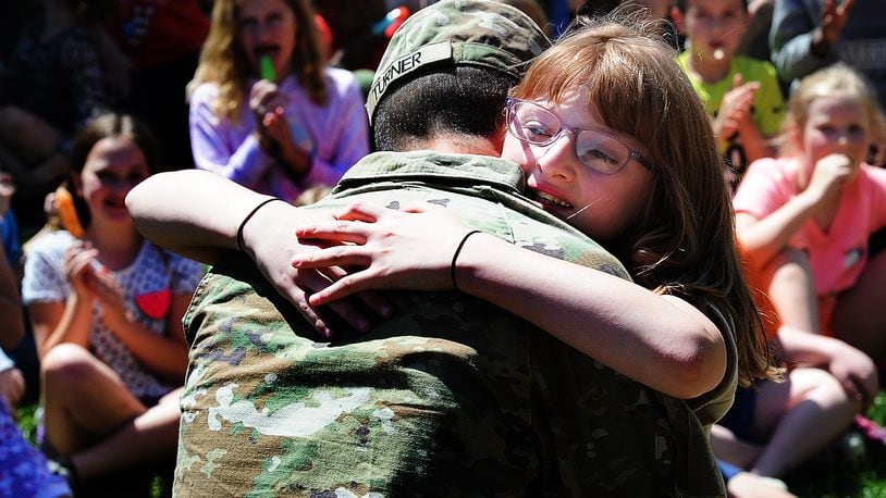 Oakwood Elementary third grader Maddisyn Beaty hugs her father, Private Jacob Turner, after he surprised her at her school Thursday, April 18, 2024. Turner had been gone for seven months for training. MARSHALL GORBY\STAFF