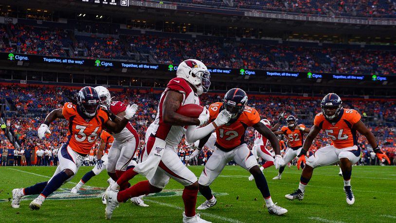 DENVER, CO - AUGUST 29: Pharoh Cooper #12 of the Arizona Cardinals is forced out of bounds by Fred Brown #19, Trey Marshall #36, and Josh Watson #54 of the Denver Broncos during the first quarter of a preseason National Football League game at Broncos Stadium at Mile High on August 29, 2019 in Denver, Colorado. (Photo by Dustin Bradford/Getty Images)