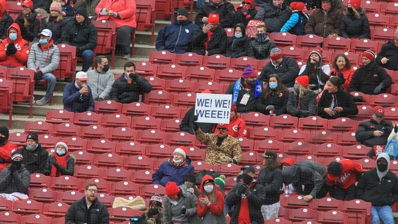 A fan holds up a sign as the Reds play the Cardinals on Opening Day on Thursday, April 1, 2021, at Great American Ball Park in Cincinnati. David Jablonski/Staff