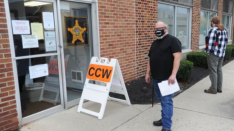 People line up outside the Greene County Sheriff's office Thursday morning to apply for a CCW permit. MARSHALL GORBY\STAFF