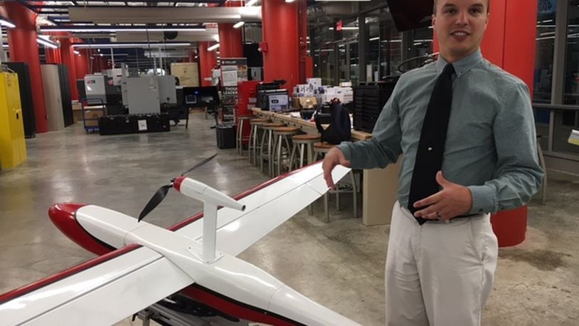 In this file photo, Andrew Shepherd, who heads Sinclair Community College’s unmanned aerial vehicles program, stands next to a version of Unmanned Solutions Technology’s Pelican II fixed-wing UAV. Sinclair is a step closer to offering three bachelor’s degrees, two aviation-related and one in industrial automation. THOMAS GNAU/STAFF ORIGINAL Andrew Shepherd, who heads Sinclair Community College’s unmanned aerial vehicles program, stands next to a version of Unmanned Solutions Technology’s Pelican II fixed-wing UAV in July. THOMAS GNAU/STAFF
