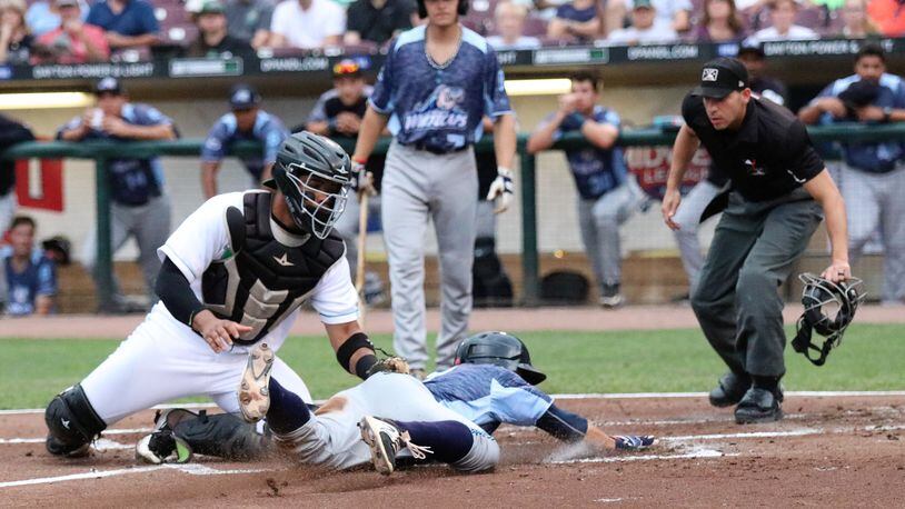 Dayton Dragons catcher Hendrik Clementina tags out West Michigan’s John Valente at the plate at Fifth Third Field on Wednesday. Dayton fell to West Michigan 6-2. CONTRIBUTED PHOTO/MICHAEL COOPER