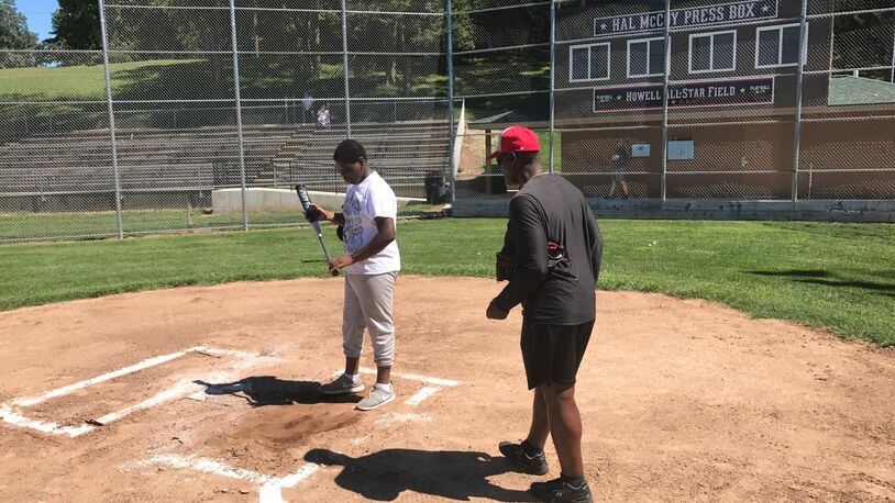 Reds legend George Foster instructs Ivan Belton on Saturday at Howell Field in Dayton. TOM ARCHDEACON/STAFF