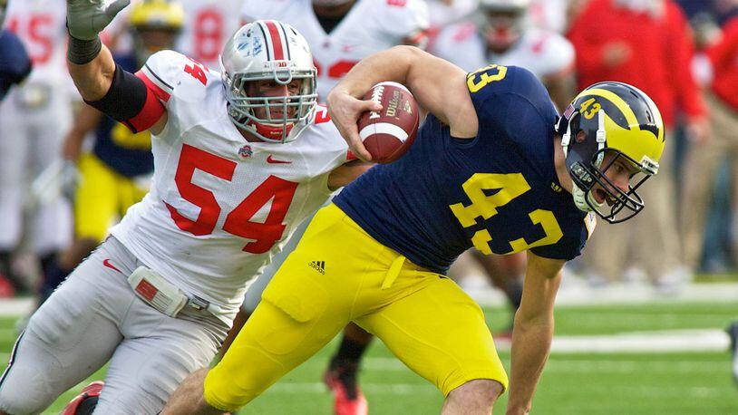 Ohio State Buckeyes defensive tackle John Simon (54) chases Michigan Wolverines punter Will Hagerup (43) after his fumble of the snap in the third quarter of the game between Ohio State and Michigan at Michigan Stadium, Ann Arbor, Michigan. Michigan defeated Ohio State 40-34.