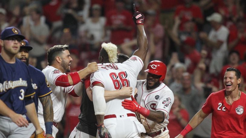 The Reds celebrate after Yasiel Puig scored the winning run against the Brewers on July 2, 2019, at Great American Ball Park in Cincinnati.