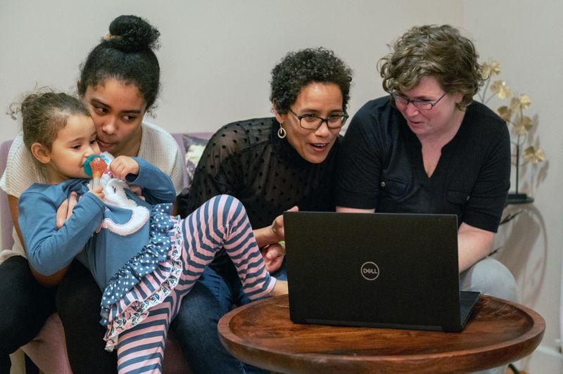 Tashel Bordere (second from right) and her wife, Dr. Kate Grossman (right) with their daughters Zaydie, 14, and Sage, 3, spoke with the kids' grandparents on both sides via Zoom video call at their home in Columbia, Mo. Instead of stilted, office-style Zoom sessions, families can use digital connections in creative ways to foster more meaningful relationships, experts say. Michael B. Thomas / The New York Times