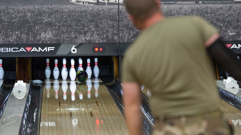 A participant watches as his shot hits the pocket during the Eagles vs. Chiefs Bowling Challenge at Wright-Patterson Air Force Base on April 9. Bowling is among numerous social activities on base that help promote the four domains of overall wellness. U.S. AIR FORCE PHOTO/WESLEY FARNSWORTH