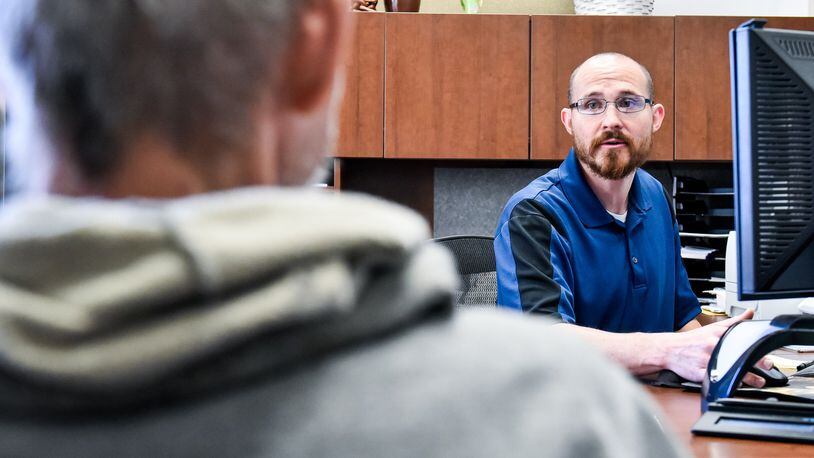 Chief Service Officer Matt Jones, right, helps Franklin English, a Navy veteran, with services during a meeting at Butler County Veterans Service Commission Thursday, May 16, 2019 in Hamilton. NICK GRAHAM/STAFF