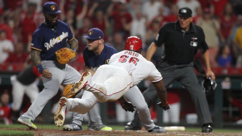 The Reds' Yasiel Puig scores the winning run in the 11th inning against the Brewers on Tuesday, July 2, 2019, at Great American Ball Park in Cincinnati.