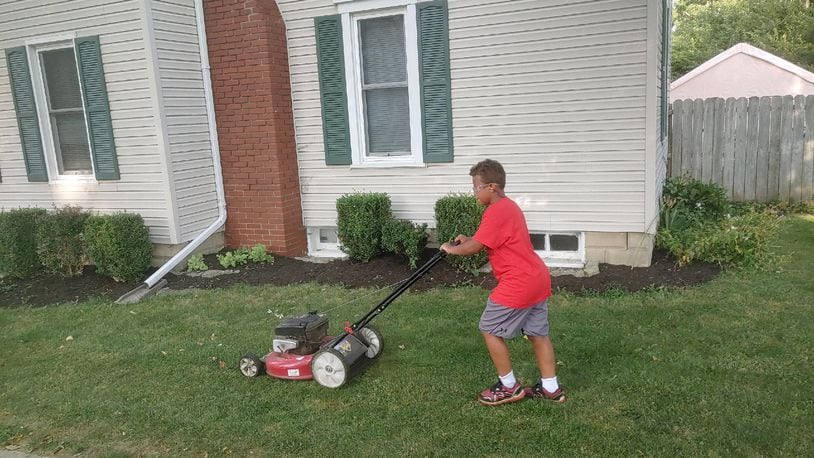Adian Harris, 9, mows a lawn over the summer as part of a challenge he took on to mow 50 lawns for the elderly, disabled, single parents or veterans. Courtesy of Ron Robert.