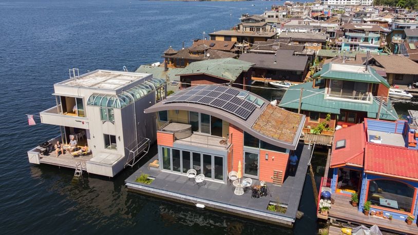 Architect Michelle Lanker; her husband, Bill Bloxom; and their doggies Bing and Arnie live on the second floating home from the left — the one with the distinctive, and distinctively sustainable, curved roofline, solar panels and vegetated roof system. G. Little Construction built the LEED Platinum-certified home in Port Townsend before it was towed to Lake Union (Steve Ringman/The Seattle Times/TNS)