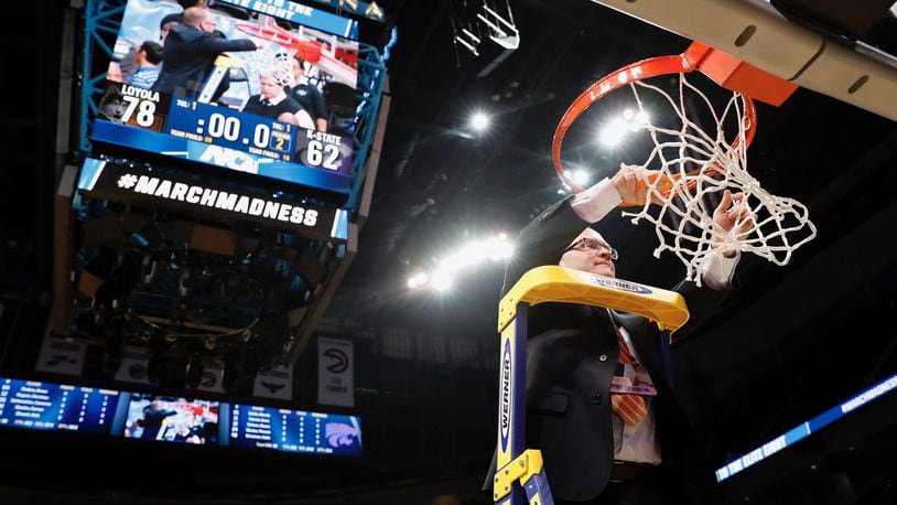 Loyola sports information director Bill Behrns cuts down the net after a victory against Kansas State on Saturday, March 24, 2018, in the South Regional final in Atlanta, Ga. Steve Woltmann/Loyola Athletics