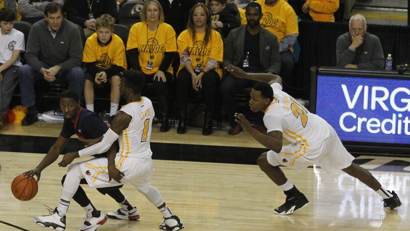 Dayton’s Scoochie Smith brings the ball up the court against Virginia Commonwealth’s JeQuan Lewis (1) and Treveon Graham, far right, on Saturday, Feb. 28, 2015, at the Siegel Center in Richmond, Va. David Jablonski/Staff